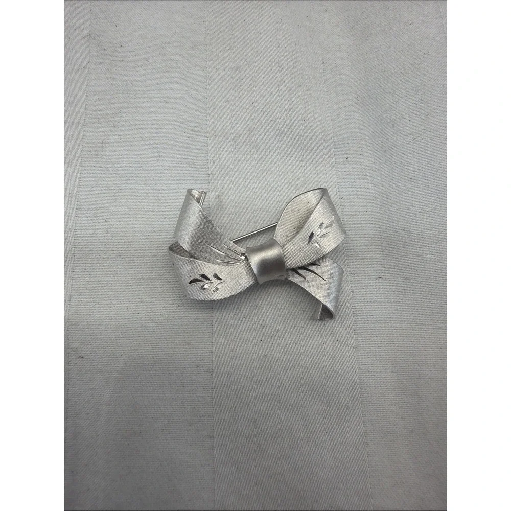 sterling silver bow brooch with a brushed, textured finish